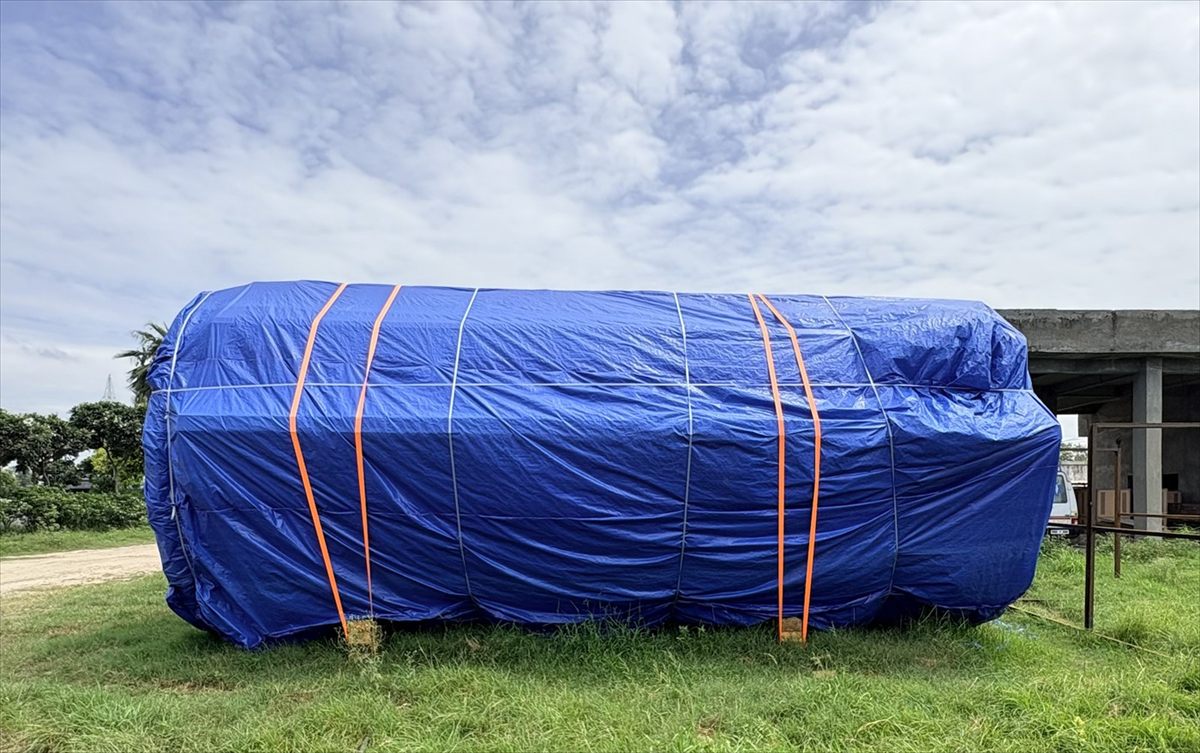 Orange lashing straps at measured centres holding a tarpaulin cover tight