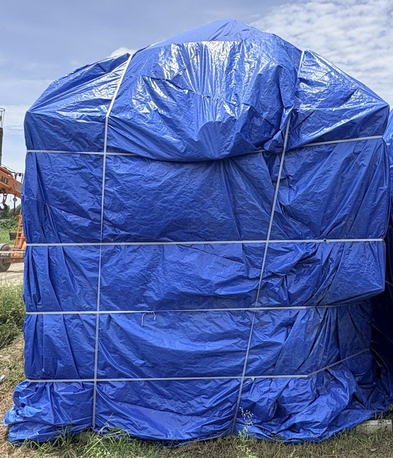 Tarpaulin cover tensioned and banded at every course on a skid mounted unit
