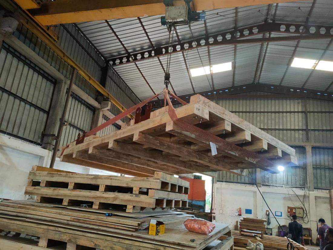 Crane lifting an engineered heavy duty timber skid for machinery packaging